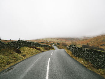 Road amidst mountains against sky