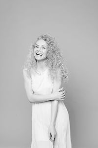 Portrait of a smiling young woman against white background