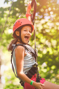 Happy girl hanging from tree