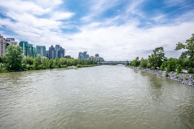 River amidst buildings in city against sky