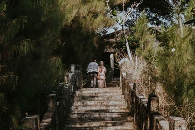 Rear view of woman walking on footbridge
