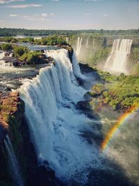 Scenic view of waterfall against sky