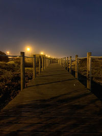 View of empty footpath at night