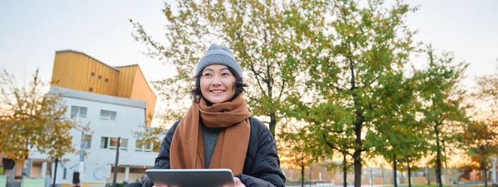 Low angle view of woman standing against trees