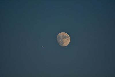 Low angle view of moon against blue sky