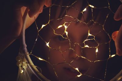 Close-up of hand holding illuminated dreamcatcher