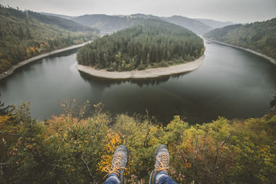 Low section of person flying over river