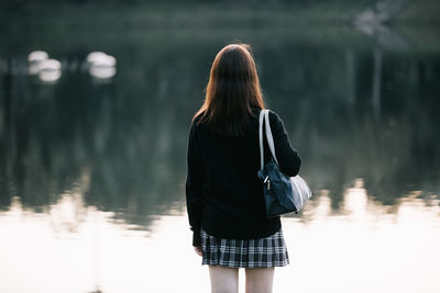 Rear view of woman standing in lake