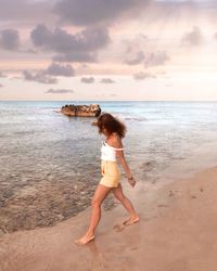 Full length of boy on beach against sky