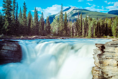 Scenic view of waterfall against sky