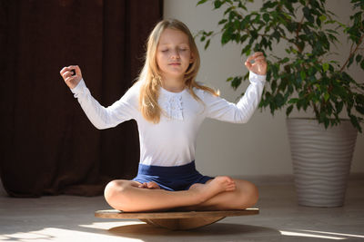 Full length of woman sitting against wall