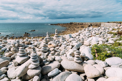 Rocks by sea shore against sky