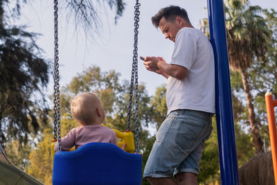 Rear view of woman swinging at playground