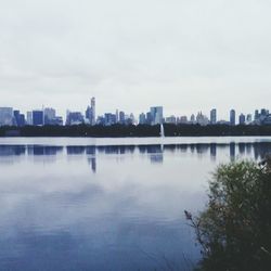 Scenic view of river with cityscape in background