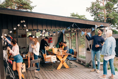 Young male and female friends preparing for party at cottage