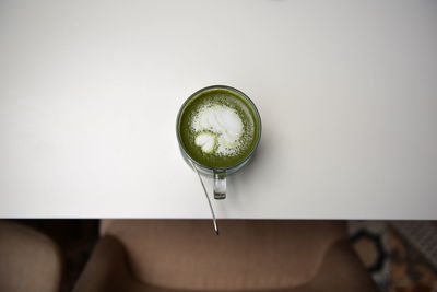 Directly above shot of matcha tea served on white table