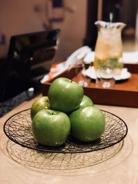 Close-up of granny smith apples in plate on table