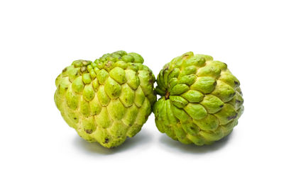 Close-up of green fruits against white background