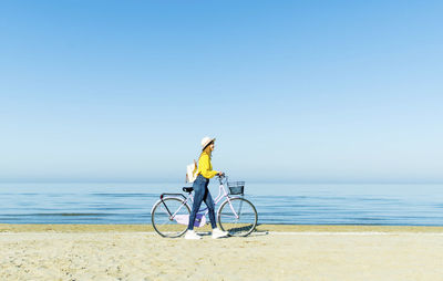 Bicycle on beach against clear sky