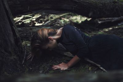 Woman lying down in forest