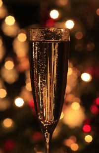 Close-up of wine glass against illuminated lights