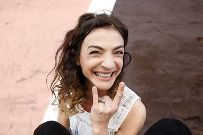 Adult woman gesturing in front of a pink and brown wall, san sebastian