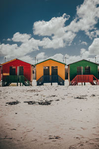 Beach huts by buildings against sky on sunny day muizenberg cape town africa 