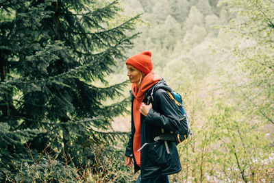 Woman hiker walks through the forest in the mountains