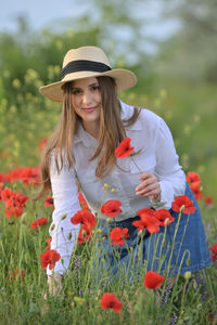 Portrait of beautiful young woman standing on field