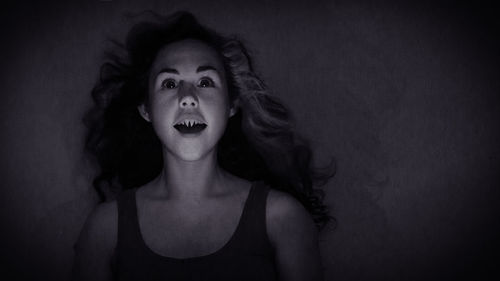 Spooky young woman against wall during halloween