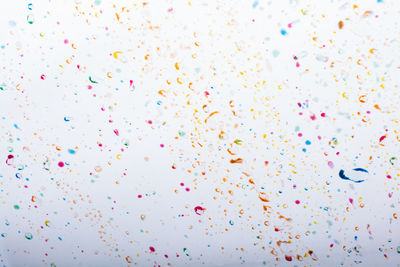 Low angle view of multi colored balloons against sky