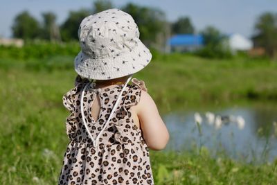 Rear view of girl standing on field