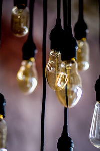 Close-up of illuminated light bulb hanging on table