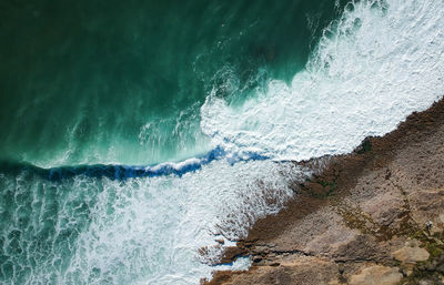 Aerial view of waves splashing on rocks