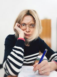 Portrait of young woman writing in book at home