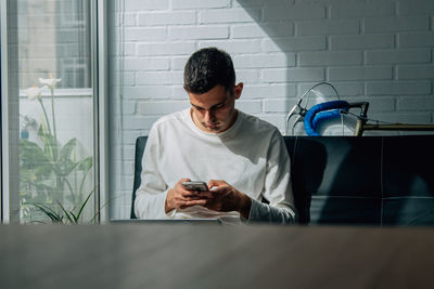 Man at home working or studying with mobile phone and computer