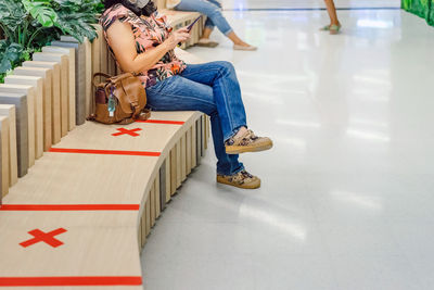 Rear view of woman sitting on chair at home
