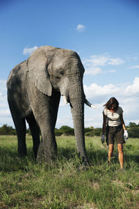 Mature woman standing next to elephant