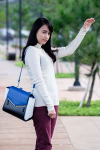 Young woman standing on footpath at park