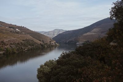 Scenic view of river amidst mountains against sky