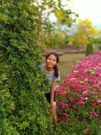 Portrait of a smiling woman standing against plants