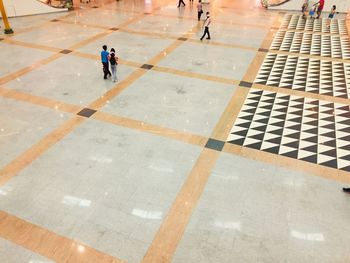 High angle view of people walking on tiled floor