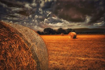 Scenic view of field against cloudy sky