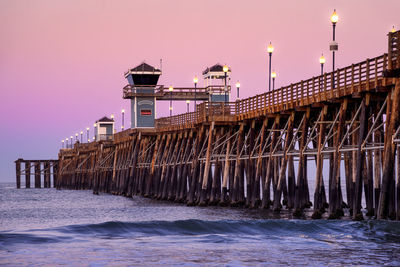 Pier over sea against sky during sunset