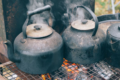 Close-up of rusty metal container on wood burning stove