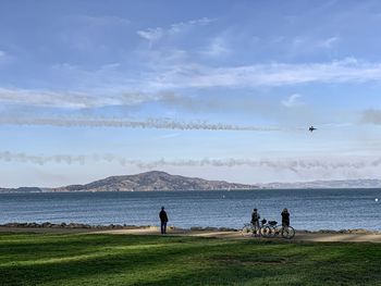 People on beach against sky