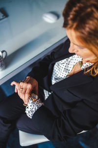 Midsection of businesswoman checking the time while sitting in chair