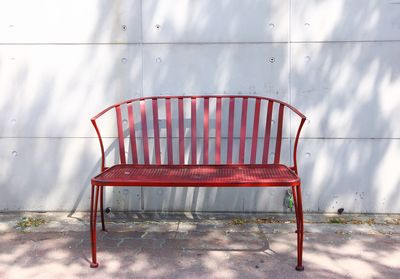 Empty chairs and table against wall