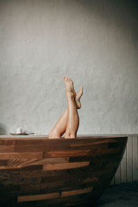 The woman takes a bath at home, only her legs are visible