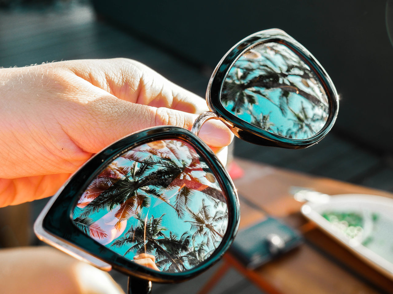 human hand, human body part, hand, holding, finger, human finger, one person, glass - material, body part, close-up, real people, reflection, unrecognizable person, indoors, focus on foreground, magnifying glass, transparent, personal perspective, table, personal accessory